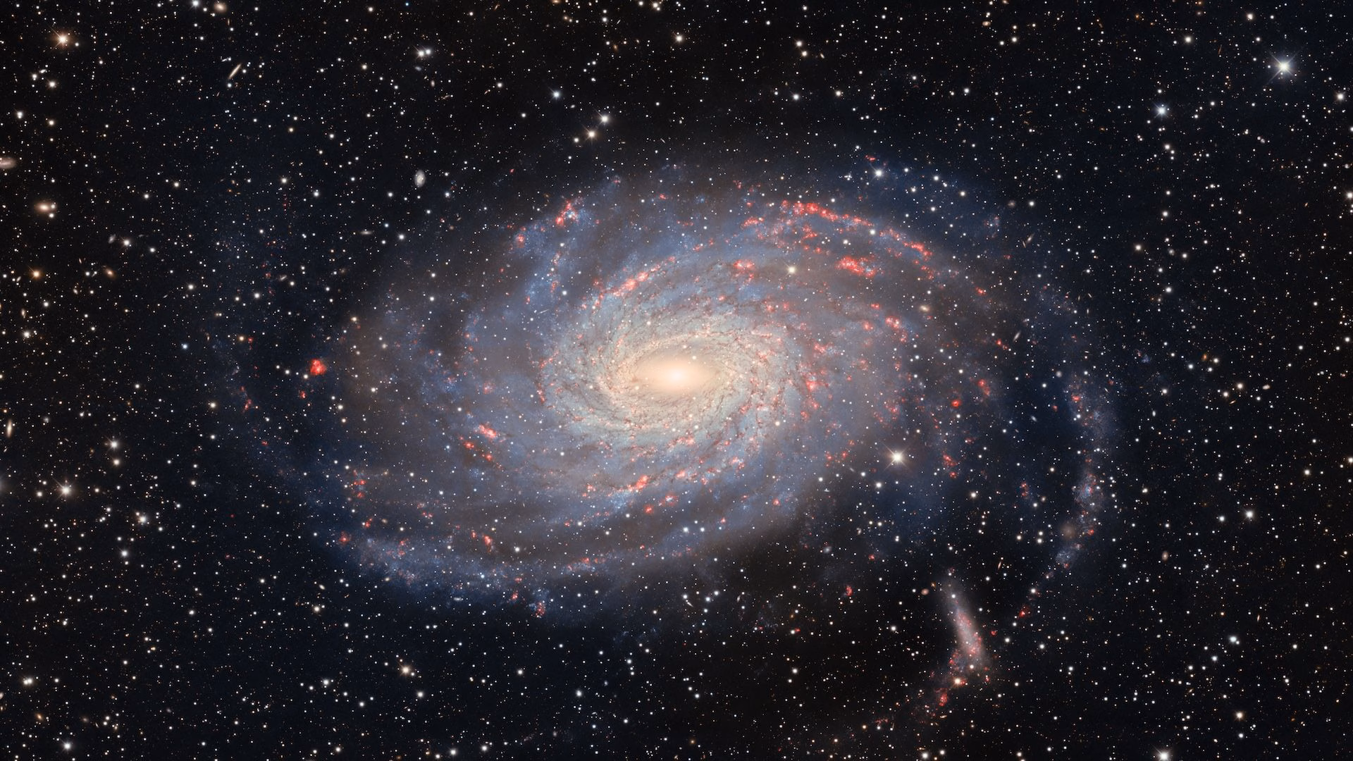 Behold NGC 6744, a spiral galaxy bearing similarities to our home galaxy, the Milky Way. This cosmic twin is captured here in stunning detail by the Dark Energy Camera (DECam) on the Víctor M. Blanco 4-meter Telescope at the U.S. National Science Foundation Cerro Tololo Inter-American Observatory (CTIO), a Program of NSF NOIRLab in Chile. Located around 30 million light-years away in the constellation Pavo, NGC 6744 exhibits a luminous core and spiral arms spanning 175,000 light-years across, a larger but similar anatomy to our Milky Way. Moreover, to the lower right of NGC 6744, at the end of the spiral arm, is a faint blob. This is its companion galaxy known as NGC 6744A. The companionship between these galaxies is analogous to that between the Milky Way and its dwarf companion the Large Magellanic Cloud. Though it’s impossible to get an external view of our galaxy, these similarities offer insight into how the Milky Way might look to a distant observer. This is one of the deepest images of NGC 6744 ever taken, and keen observers can spy the faint extended arm on the left hand side of the galaxy — rarely visible in most images. This image is part of the DESI Legacy Imaging Surveys, an ambitious effort to construct the largest 3D map of the night sky with the DOE-built DECam on the Blanco Telescope at NSF CTIO and other Programs of NSF NOIRLab.